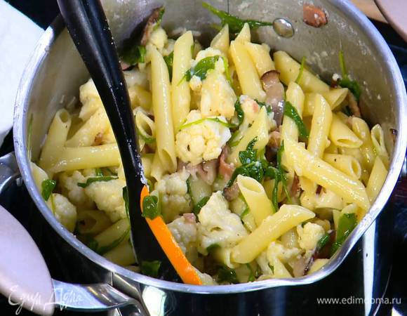 К горячей пасте добавить обжаренную грудинку, руколу, запеченную цветную капусту, половину натертого сыра и все перемешать. Если нужно, влить немного воды, в которой варилась паста.