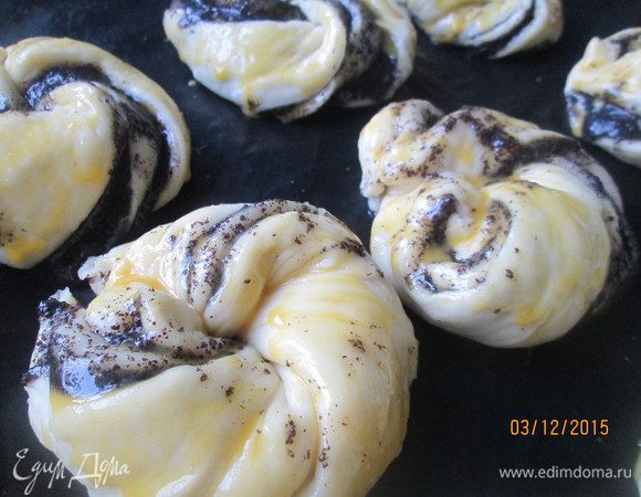 Выкладываем на противень, застеленный бумагой для выпечки. Я пользуюсь для выпечки уже несколько лет тонким силиконовым ковриком. Смазываем каждую плюшечку смесью желтка с водой.