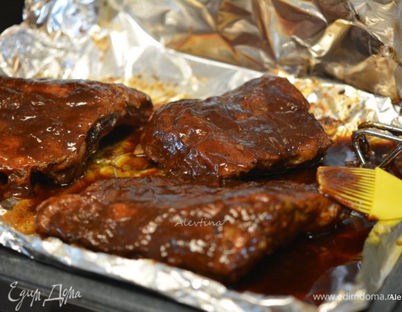 Смешать соус барбекю с жидким медом. Смазать ребрышки со всех сторон. Вернуть в духовку на 10 минут.