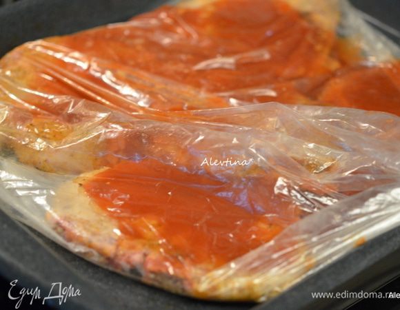 Переложить в пакет или в рукав для готовки и залить смешанным кетчупом с водой и сухими специями. Закрыть, сделать 4 надреза сверху в разных местах. Поставить в разогретую духовку на 180°С на 40-45 минут.
