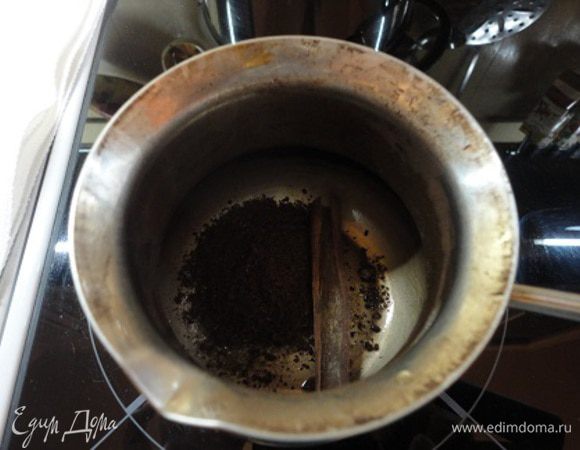 В турку всыпать сахар, свежемолотый кофе, гвоздику и корицу.