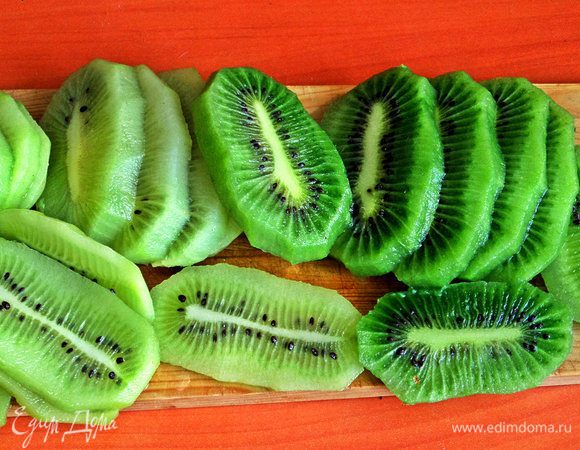 Киви очистить и разрезать вдоль не очень тонко.