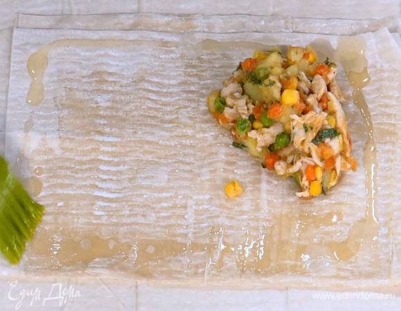 Каждый лист фило смазать оливковым маслом, сложить пополам, еще раз смазать маслом и сложить пополам, затем на уголок выложить начинку, промазать маслом края и накрыть свободным углом теста, чтобы получился треугольник.