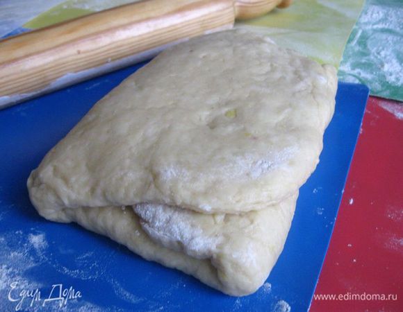 Раскатать на посыпанной мукой поверхности в прямоугольник чуть меньше толщины пальца. Сложить его в три раза и затем раскатать в прямоугольник с узкой стороной 25 см и другой — очень длинной (длина будущей «улитки»). 