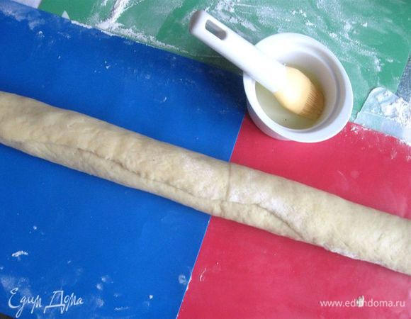 Равномерно нанести начинку, отступив 1 см по длинной стороне дальней от вас. Так же отступить на 1 см по двум коротким сторонам. Нанести кисточкой белок на свободное от начинки тесто. Скрутить тонкий рулет немного наискосок, чуть по диагонали, аккуратно пройтись вдоль по рулету руками, слегка сжимая его, уплотняя и одновременно делая немного тоньше, а затем бережно, немного (тесто нежное) выкрутить по спирали, как выкручиваете мокрую тряпку.