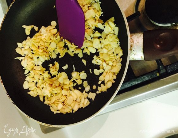 Когда сахар весь растаял, всыпаем миндальные лепестки, хорошенько быстренько мешаем.