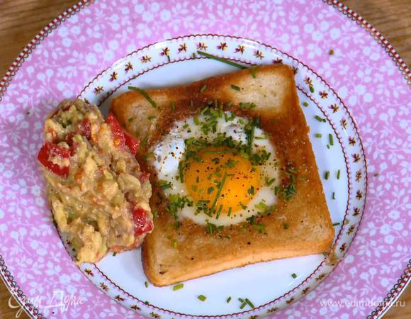 Шнитт-лук мелко порубить и посыпать поджаренный хлеб с яйцом. Подавать гренки с соусом из авокадо.