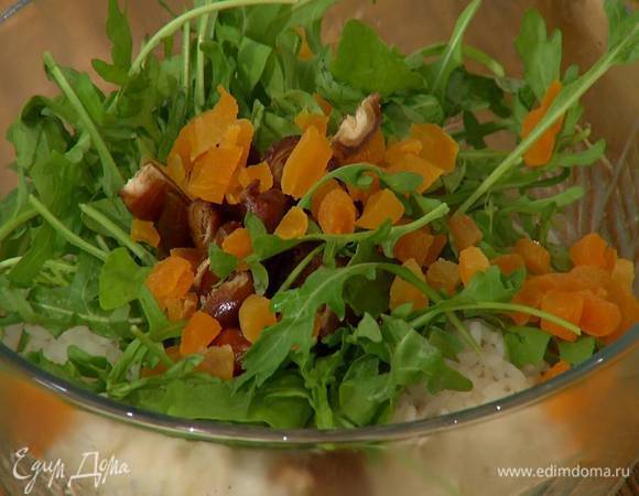 Добавить руколу, сухофрукты, влить оливковое масло, посолить, поперчить и перемешать.