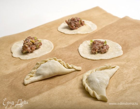 Сформировать из теста колбаску, нарезать на небольшие кусочки и раскатать из них кружки. Выложить в середину каждого кружка фарш и защипнуть края.
