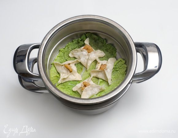 На дно пароварки положить листья салата и поместить решетки с дим сум так, чтобы между ними был промежуток в 2 см. Готовить на сильном огне в течение 7 минут.