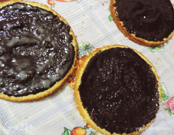 Каждый пласт бисквита смазываем шоколадной массой. Немного ждем, пока она впитается и загустеет.