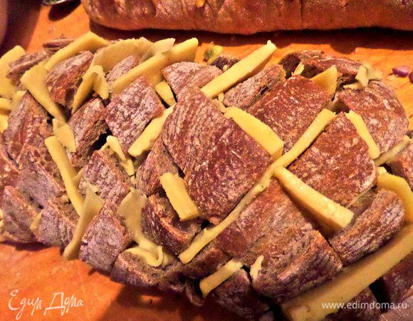 Было 2 покупные (пекут рядом с домом прямо в супермаркете) чиабатты: белая и серая. Делаем надрезы глубоко, но не до конца, крест-на-крест. Сыр дольками заталкиваем в прорези.