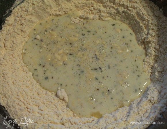 Муку смешать с содой и просеять. В муку вылить яичную смесь и замесить тесто.