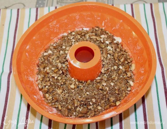 Выложите половину теста в смазанную форму, сверху выложите ореховую смесь.