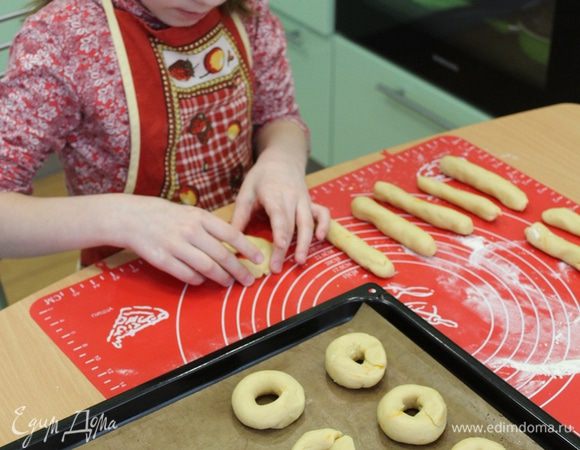 Разделить тесто на кусочки, скатать небольшие колбаски, соединить концы в колечки. Разложить колечки на противень с бумагой для выпечки и отправить в разогретую духовку 180°C, на 10-15 минут.