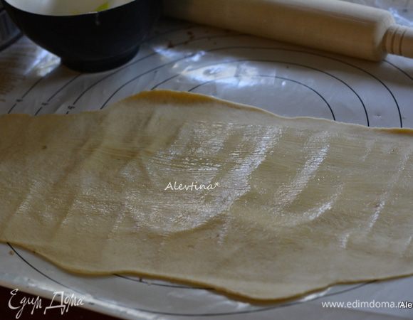 Растопить 2 ст. л. сливочного масла.
Раскатать один кусок в прямоугольную форму тонко, смазать маслом.