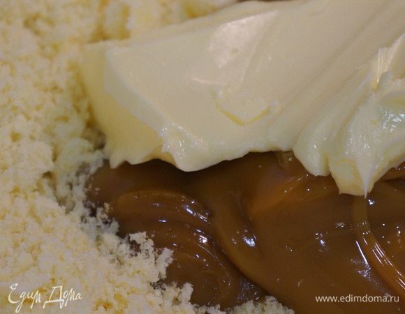 Добавить сливочное масло и варёную сгущенку, хорошенько перемешать до однородности. Сформировать конфетки и обвалять их в кунжутных семечках. 
Можно вместо кунжута использовать кокосовую стружку, но, на мой вкус, кунжут сюда лучше подходит.