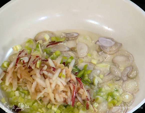 В сковороду с шалотом добавить измельченный зеленый лук и натертое яблоко, все перемешать и обжаривать, пока не выпарится лишняя жидкость.