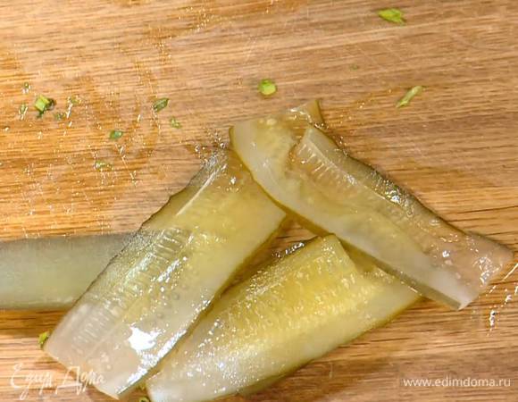 Соленый огурец нарезать вдоль тонкими полосками.