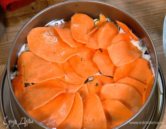 Разъемную форму для выпечки смазать оливковым маслом, тонким слоем выложить рикотту с яйцами, посыпать измельченной зеленью и разложить сверху ломтики батата.