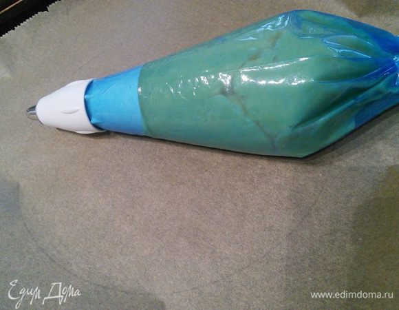 Заварное тесто поместить в кулинарный мешок с насадкой "розочка". На пергаментной бумаге нарисовать карандашом круг диаметром 25 см. Духовку разогреть до 225°С. 