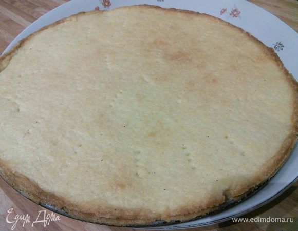 Смазать разъёмную форму диаметром 26 см маслом, посыпать мукой. Песочное тесто раскатать по дну формы ровным пластом, проколоть вилкой в нескольких местах и выпекать в заранее разогретой до 200°С духовке приблизительно 15 минут, остудить. 