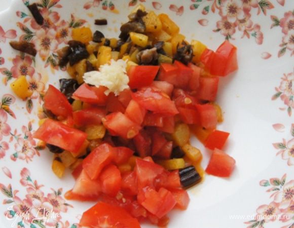 Небольшой помидор нарезать мелкими кубиками и смешать с обжаренным кабачком и грибами. Добавить чеснок, измельченный прессом.