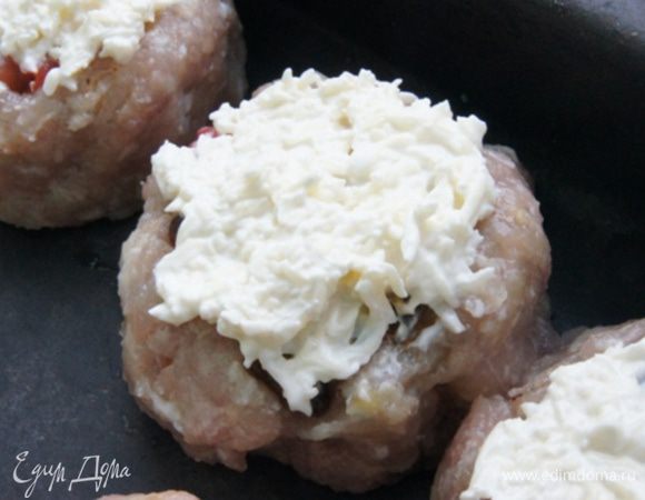 Сыр натереть на мелкой терке, смешать со сметаной и намазать сверху башенок. Присыпать паприкой и выложить в форму для запекания.