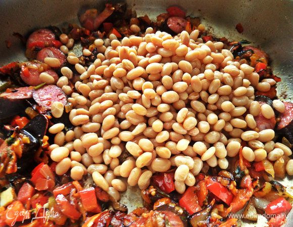 Высыпаем теперь фасоль, повторяю — готовую. Вливаем воду или бульон.