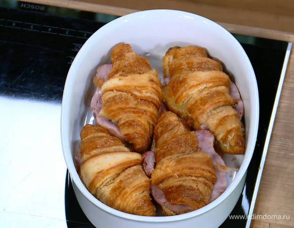 На половинки с маслом выложить сыр, на половинки с горчицей — ветчину. Сложить вместе половинки круассанов, выложить в жаропрочную керамическую форму, залить яйцами с молоком и запекать в разогретой духовке 20 минут.
