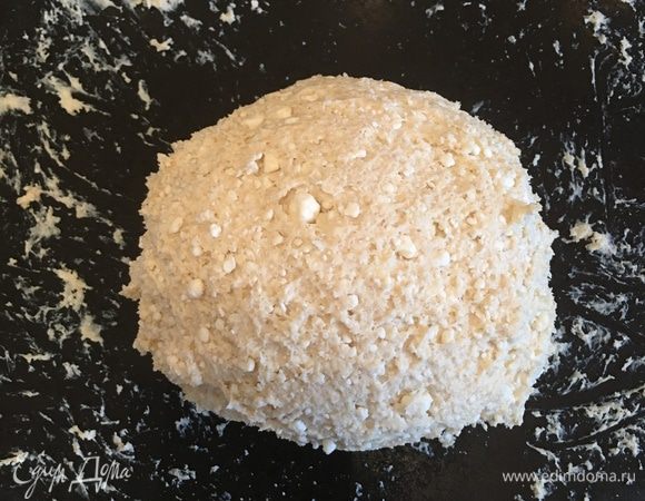 Соединяем обе смеси и хорошенько вымешиваем рукой до однородного состояния. Затем перекладываем на стол и продолжаем вымешивать еще 20 минут до состояния липкого, но уже цельного теста (т.е в начале вымешивания будет ощущение, что мы просто перебираем пальцами творог, но уже после приблизительно 10 минут вымешивания тесто начнет принимать более-менее знакомую структуру, а если после 20 минут дать ему полежать еще минут 10, то тесто примет идеальную форму). Я вымешивала руками, но думаю, что можно это делать и миксером с режимом для вымешивания теста.