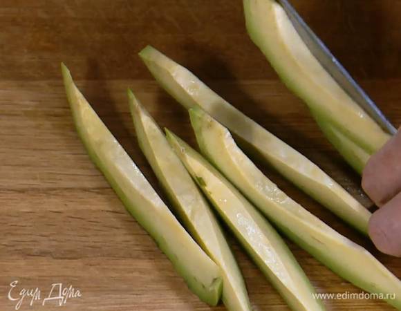 Авокадо, удалив косточку, нарезать тонкими полосками.