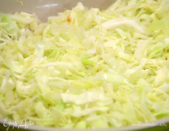 Капусту мелко нашинковать, добавить к луку, перемешать и обжарить, затем посолить, накрыть сковороду крышкой и тушить все на медленном огне.
