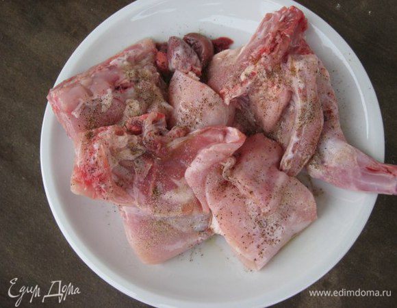 Кролика разрезать на порционные куски, сложить в миску, сбрызнуть уксусом, оливковым маслом, посолить, посыпать специями. Оставить мариноваться мясо на полчаса.