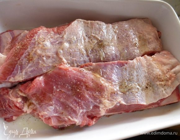 Ребра выкладываем в керамическую форму, в которой их будем готовить. Натираем ребра солью и свежемолотым перцем (у меня смесь из 5 перцев), сбрызгиваем оливковым маслом.