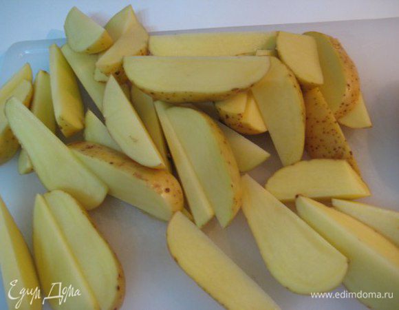 Разогреть духовку до 200°С. Картофель помыть, обсушить, порезать на дольки. Обсыпать паприкой, солью, мелкорубленым розмарином, влить оливковое масло, перемешать.