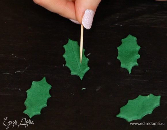 2 вариант — веточки омелы. Из мастики/марципана с помощью формочки вырезаем листики и зубочисткой рисуем прожилки. Если используете мастику, оставьте её немного подсушиться, чтобы листья хорошо держали форму.