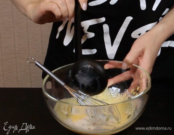 Добавьте часть горячего молока и сразу перемешайте.