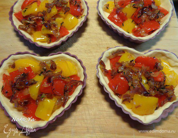 Заполним каждую формочку перцем, который выложим выпуклой сторой вверх, и красным луком.