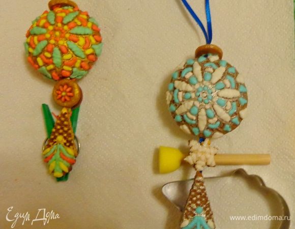 Вложить в пряник сюрприз (я увлеклась и не сфотографировала этот шаг) и склеить шары, оставив часть тесьмы для наклейки нижних частей игрушки. Дать высохнуть, используя подручные средства.