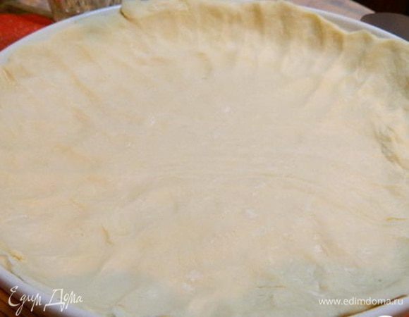 Тесто разморозить и выложить в форму смазанную маслом. Сделать бортики.Наколоть поверхность теста вилкой.