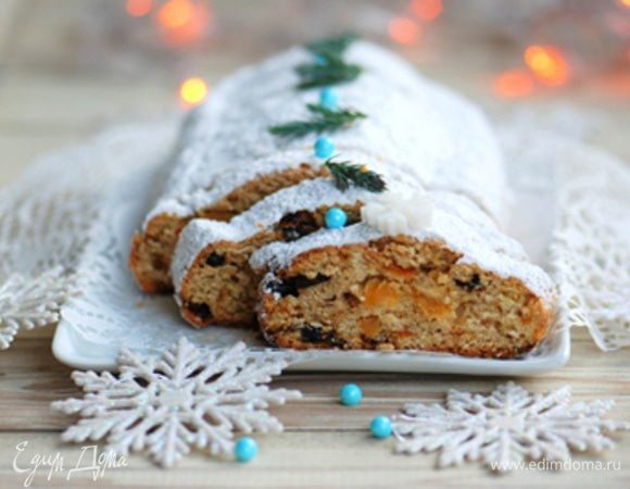 Теплый штоллен смазать смесью масла и сока. Обильно посыпать сахарной пудрой.