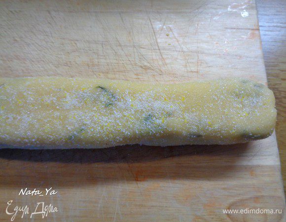 Достать тесто из холодильника. Разделить его на 2 части. Каждую часть скатать колбаской (или брусочком) 3-4 см. диаметром и хорошо прокатать в смеси сахара с лимонной цедрой. 