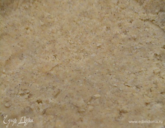 Форму диаметром 22 см выстелить бумагой для выпечки. Выложить тесто-крошку и хорошо утрамбовать ложкой.