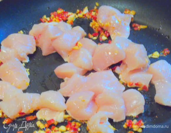 Куриное филе нарежьте кубиками и добавьте в сковороду к чесноку, чили и имбирю.