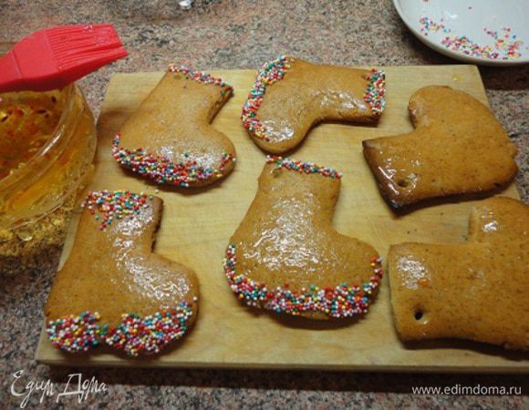 Сапожки сразу же, пока они горячие, смазать сиропом от любого светлого варенья (у меня облепиховое) и украсить сахарной посыпкой.