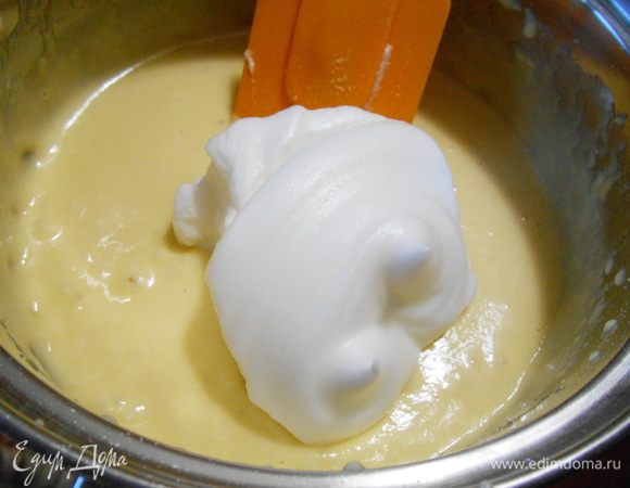 В три приема ввести в тесто взбитые белки. Каждый раз аккуратно перемешивать лопаткой движениями сверху вниз, от краев к центру.
