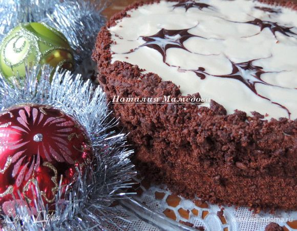 Когда мусс застынет, торт готов и его можно есть.
Мне захотелось торт украсить дополнительно. Верх торта я покрыла белой глазурью. Для ее приготовления растопить белый шоколад со сливочным маслом и молоком, дать остыть до комнатной температуры и вылить на верх торта. По белой глазури я нарисовала разводы растопленным черным шоколадом с добавлением небольшого количества рафинированного растительного масла. Бока торта обсыпала трюфельной крошкой (можно взять вафли, печенье, бисквитную крошку, орехи, — все, что будет под рукой и покажется уместным).