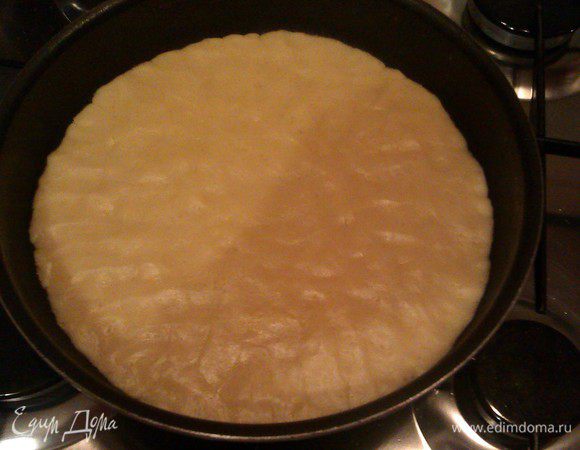 Делим тесто на две части. Можно одну взять 2/3 и вторую 1/3, но я делала ровно пополам. Одну часть (меньшую) убираем в морозилку на 15 минут (или больше, чтобы можно было натереть на терке потом), другую часть распределяем в форме для выпечки (как пластилин пальцами). Я ничем не смазывала, т.к. тесто с маслом, но можно и бумагу для выпечки подстелить. Делать это печенье в прямоугольной форме-классика, но у меня круглая сковорода с антипригарным покрытием (диаметр 23 см).