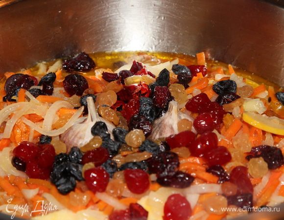 Добавляем лук и, снова помешивая, доводим лук до полупрозрачности. Теперь готовим зирвак: кладем чеснок, перец, кусочки айвы, изюм, клюкву и вишню. И заливаем все водой, в которой была айва. Где-то 500 мл. Доводим до равномерного кипения и готовим, помешивая, минут 15. После этого нужно отрегулировать на вкус соль и сахар. Даем покипеть еще минут 20-25. Кипение очень легкое.